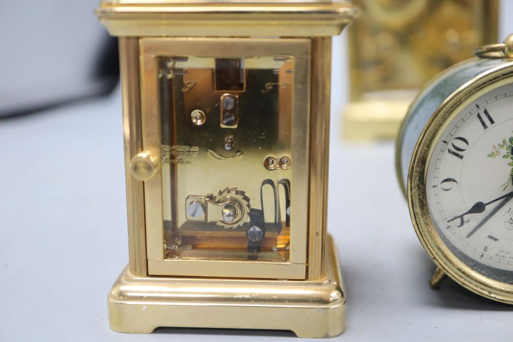 An Asprey brass cased carriage clock, another carriage clocks, two Halcyon Days carriage timepieces and an alarm clock, tallest 14cm (h